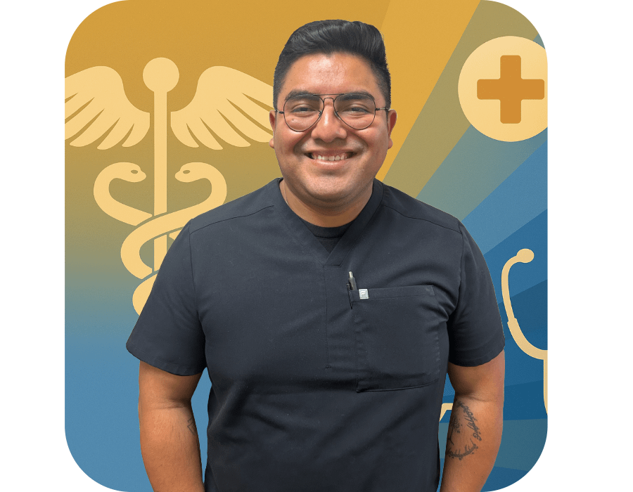 Ricardo Santiago, future medical student and former volunteer at The Neighborhood Christian Clinic, smiling in front of a Clinic-branded backdrop.